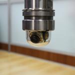 Integrated borehole focus adjusting orbit cam inspection camera